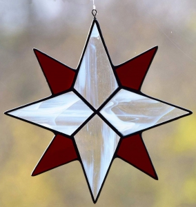 Suncatcher " Star ",eight-pointed,stained glass,tiffany technique,clear glass with white streaks,dark red,transparent,diameter ca. 13 cm,item number 30040B,manufactured in our own atelier.Carmen Harusta,Glasinsel ®,Göttingen,Germany.