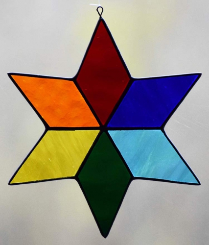 Suncatcher " Star ",stained glass,tiffany technique,red,blue,light blue,green,yellow,orange,transparent,diameter ca. 13 cm,item number 30074H,manufactured in our own atelier.Carmen Harusta,Glasinsel ®,Goettingen,Germany.