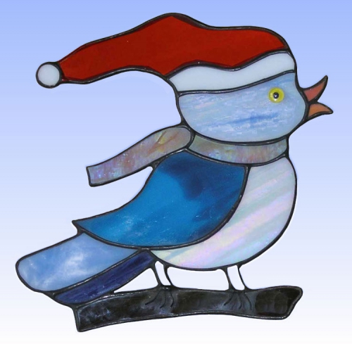 Suncatcher " Christmas-Bird ",stained glass,blue,white,red,orange,brown,opalescent,with glass eye,ca. 16 x 16 cm,item number 30021,manufactured in our own atelier.Carmen Harusta,Glasinsel ®,Goettingen,Germany.